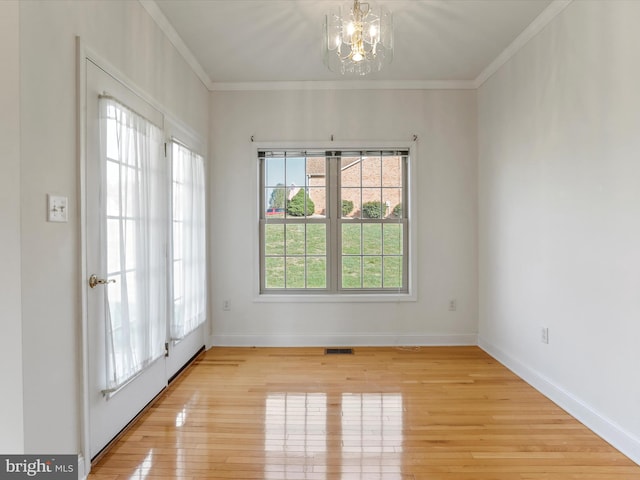 unfurnished room with a chandelier, crown molding, and light hardwood / wood-style floors