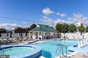 view of pool featuring a hot tub and an outdoor structure