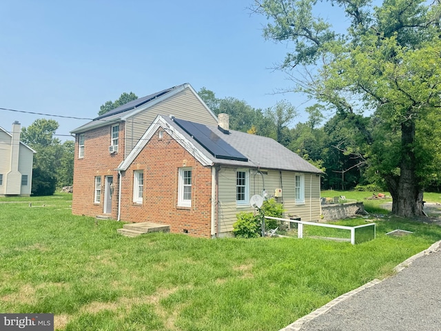 view of front of property with solar panels and a front yard