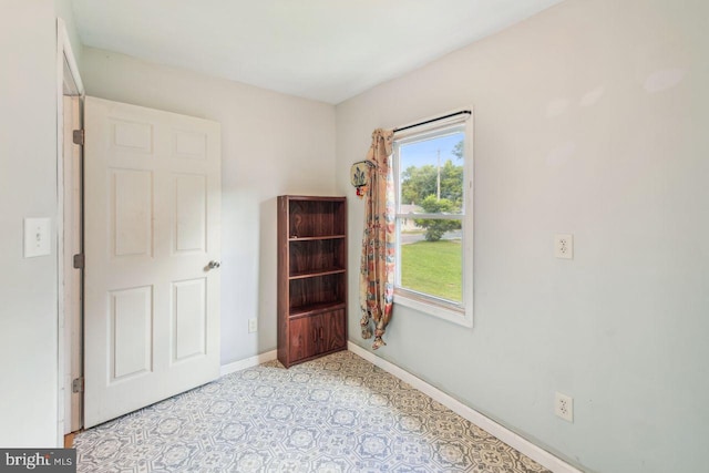 interior space featuring light floors and baseboards