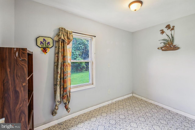 spare room with light floors, a wealth of natural light, and baseboards