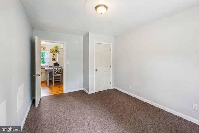 unfurnished bedroom featuring carpet floors and baseboards