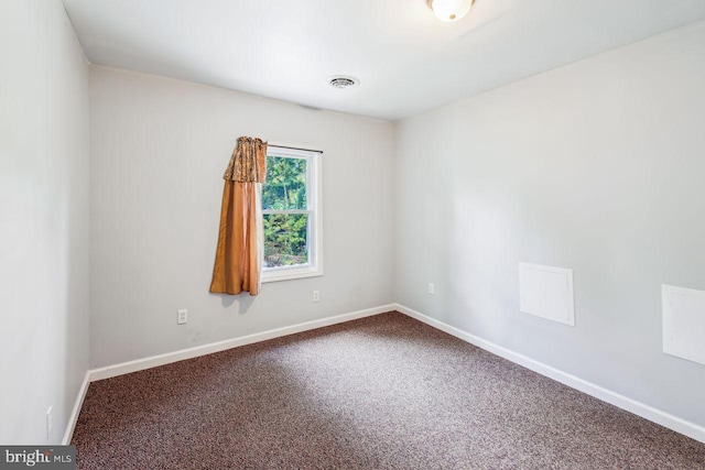 carpeted spare room with visible vents and baseboards