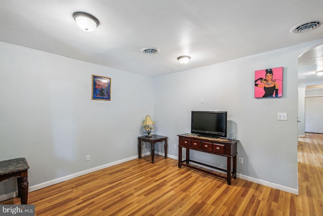 sitting room with baseboards, visible vents, and light wood finished floors