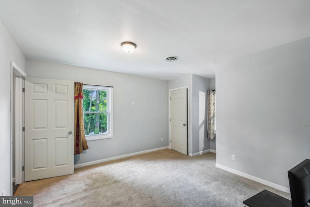 unfurnished bedroom featuring visible vents, baseboards, and light colored carpet