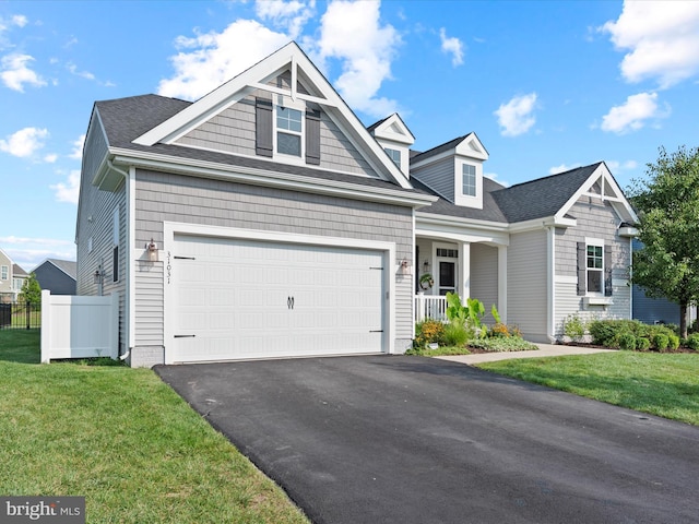 view of front of property featuring a porch, a garage, and a front lawn