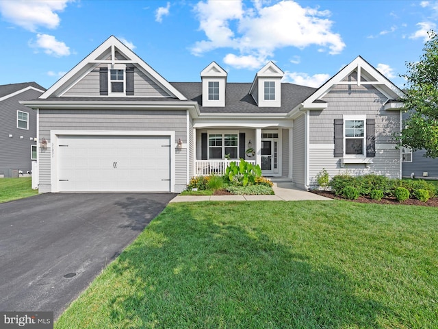 view of front of home featuring a garage, a porch, and a front yard