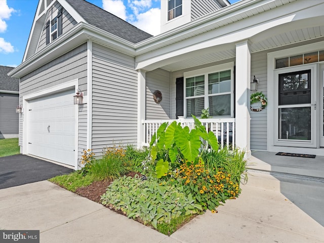 entrance to property featuring a garage and covered porch