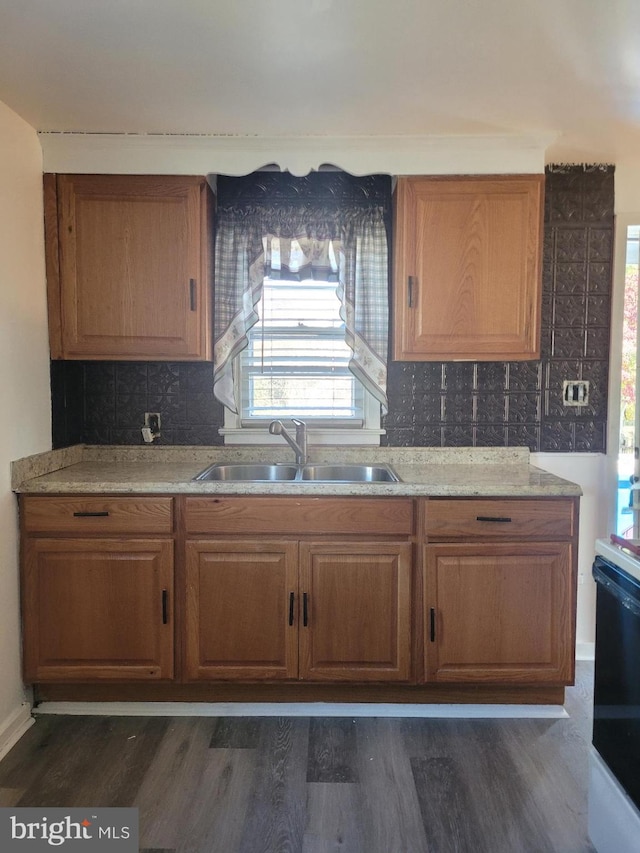 kitchen featuring tasteful backsplash, dark hardwood / wood-style flooring, sink, and black range