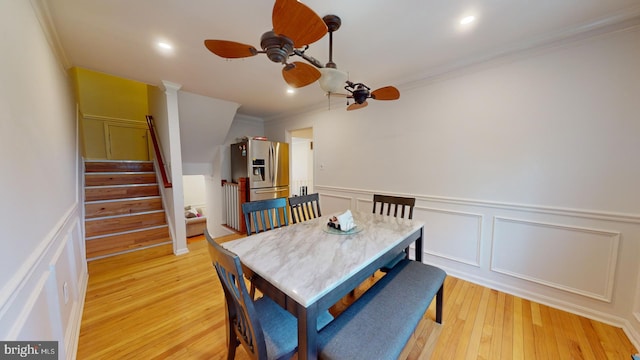 dining room featuring ceiling fan, recessed lighting, light wood-style floors, ornamental molding, and stairway