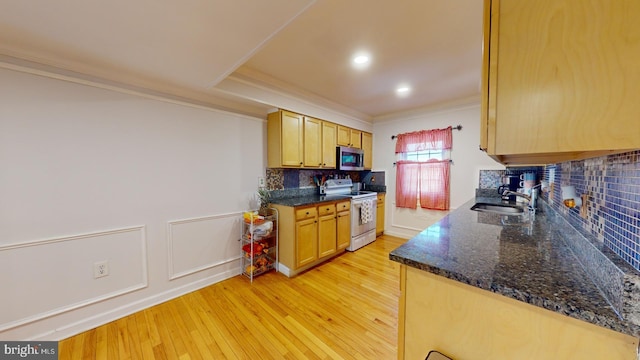 kitchen with white electric stove, light wood finished floors, stainless steel microwave, ornamental molding, and dark stone countertops