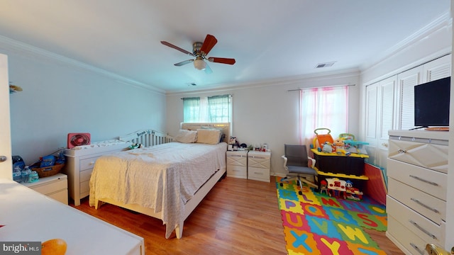 bedroom with ornamental molding, visible vents, and light wood-style floors