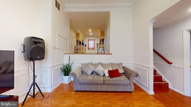 living room with light wood finished floors, visible vents, ornamental molding, stairs, and ornate columns