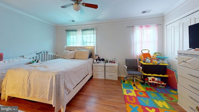 bedroom with ceiling fan, light wood-style floors, visible vents, and crown molding