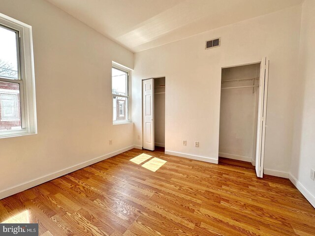 unfurnished bedroom with light wood-type flooring and multiple windows