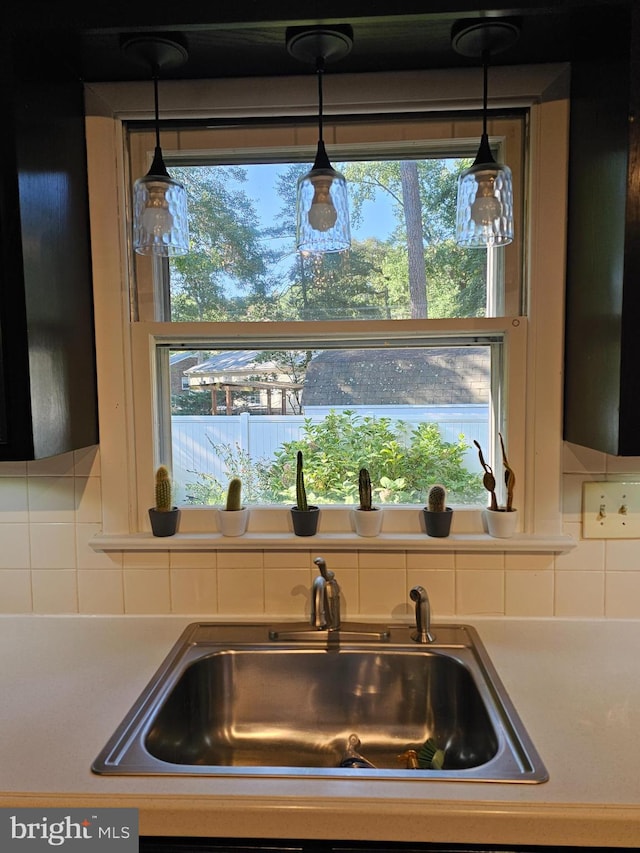 kitchen featuring a wealth of natural light, decorative backsplash, and sink