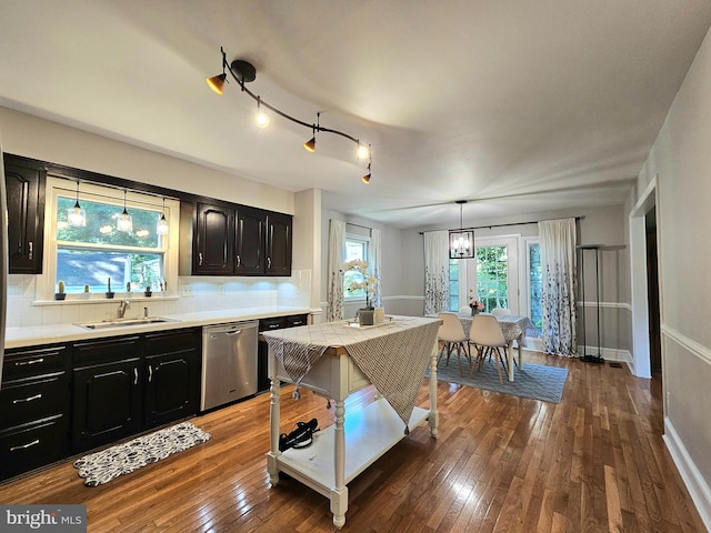 kitchen featuring sink, decorative backsplash, stainless steel dishwasher, and hardwood / wood-style floors