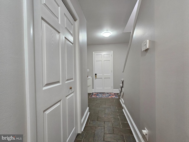 hall with dark tile patterned flooring