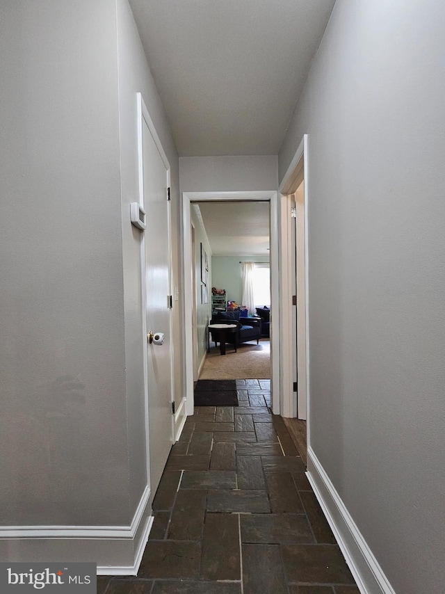 hallway featuring dark tile patterned floors