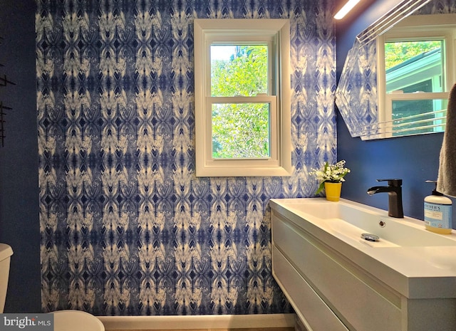 bathroom with toilet, a healthy amount of sunlight, and vanity