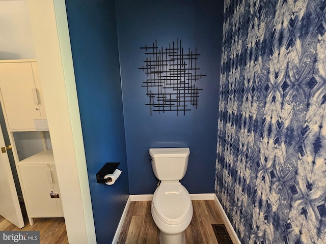 bathroom with hardwood / wood-style flooring and toilet