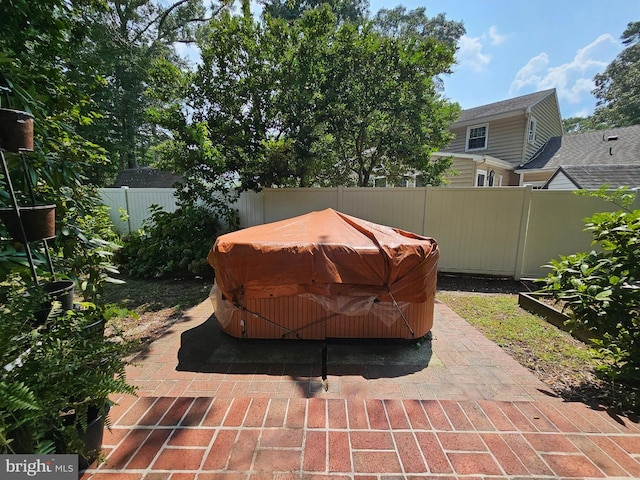 view of patio with a hot tub and a storage unit