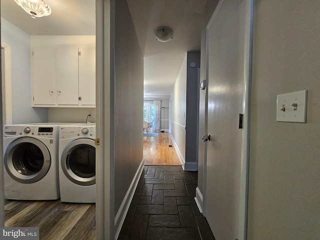 clothes washing area featuring independent washer and dryer, dark hardwood / wood-style flooring, and cabinets