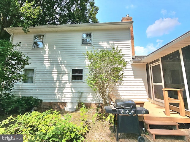 rear view of house featuring a wooden deck