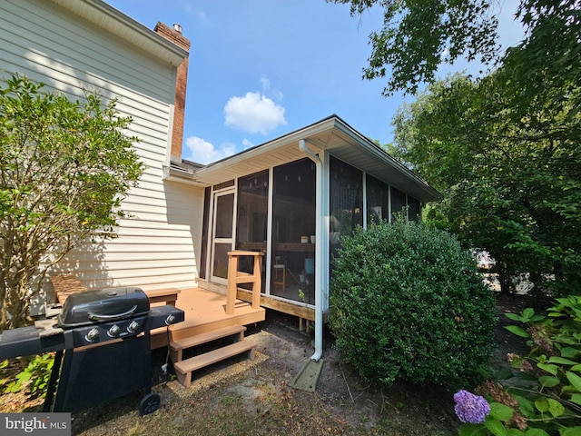 back of property featuring a wooden deck and a sunroom