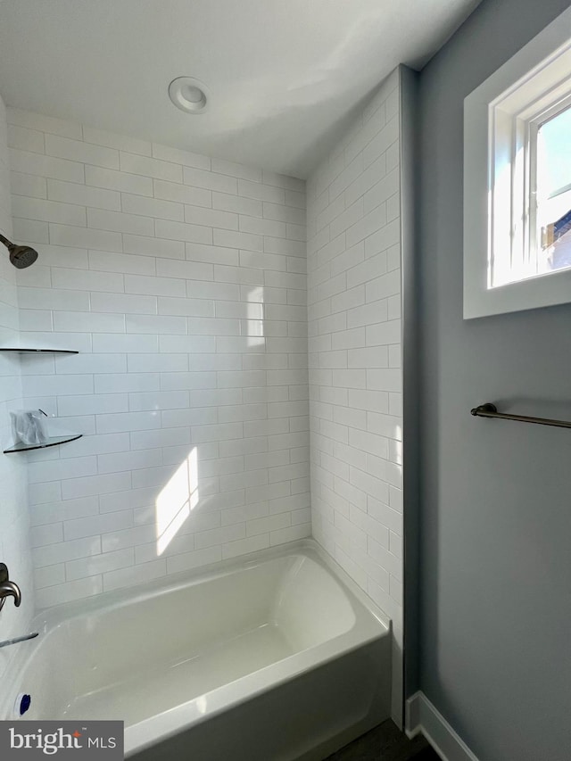 full bath with baseboards and shower / tub combination