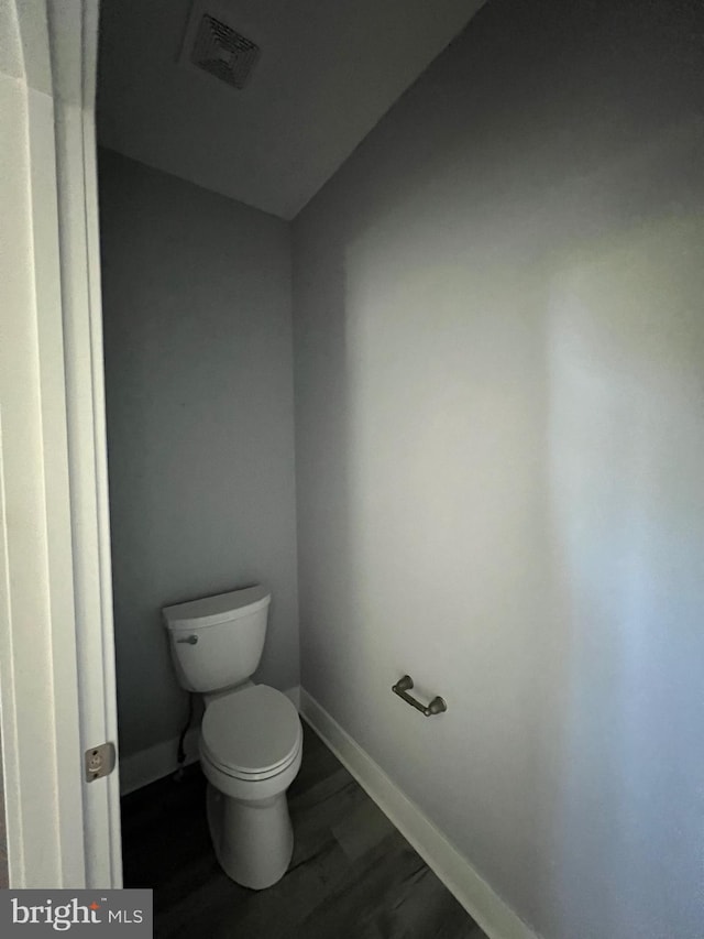 bathroom with visible vents, wood finished floors, toilet, and baseboards