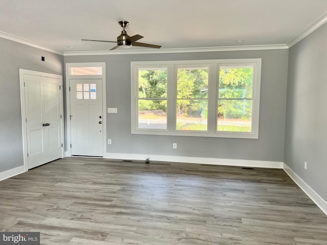 foyer featuring baseboards, light wood-style floors, a ceiling fan, and crown molding