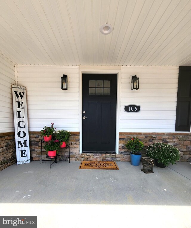 view of exterior entry featuring covered porch