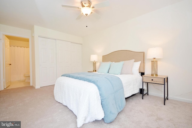 bedroom featuring a closet, ceiling fan, light colored carpet, and ensuite bath