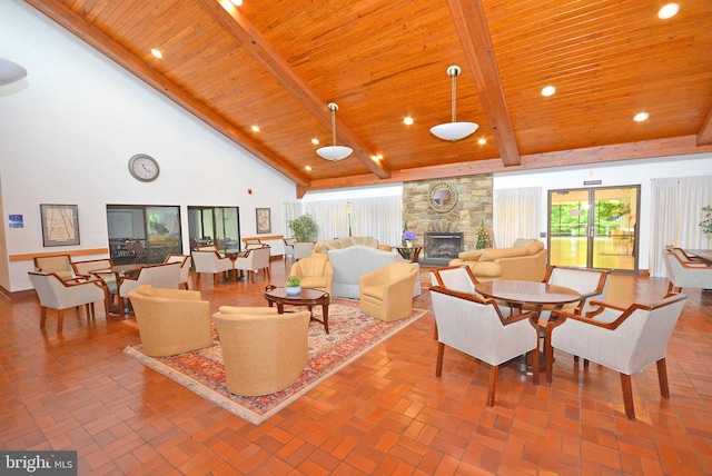 living room featuring high vaulted ceiling, wooden ceiling, and a stone fireplace