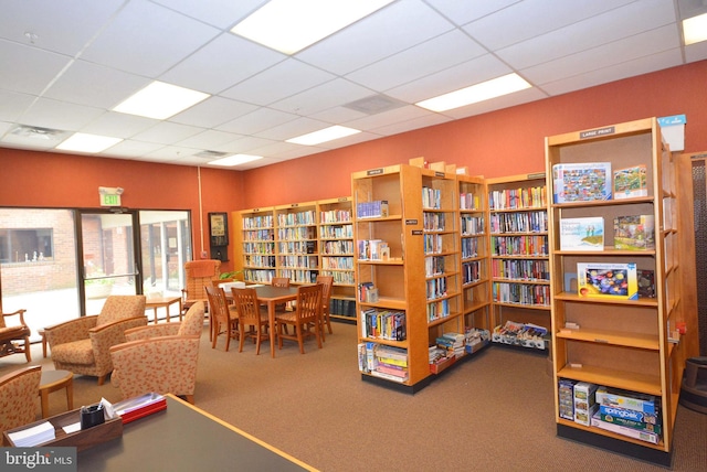 interior space with carpet floors and a drop ceiling