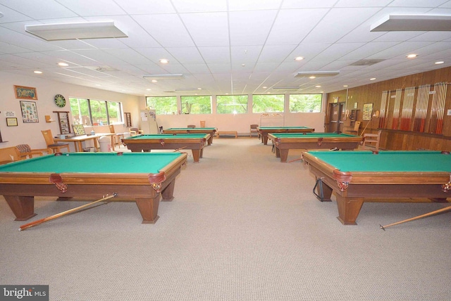 playroom featuring pool table, a paneled ceiling, light carpet, and wood walls