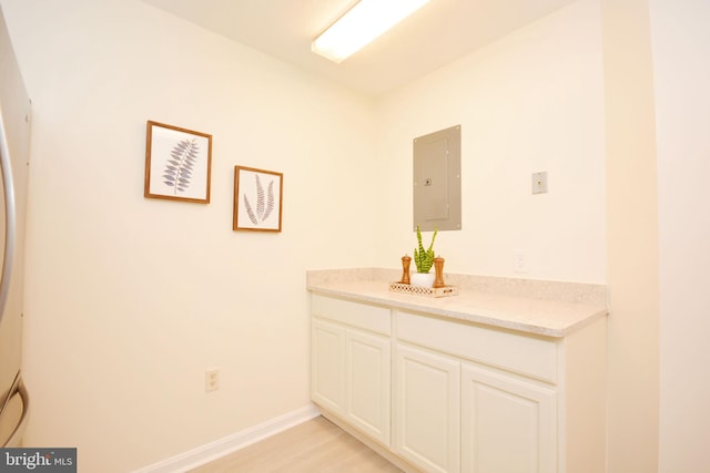 bathroom with electric panel, vanity, and wood-type flooring