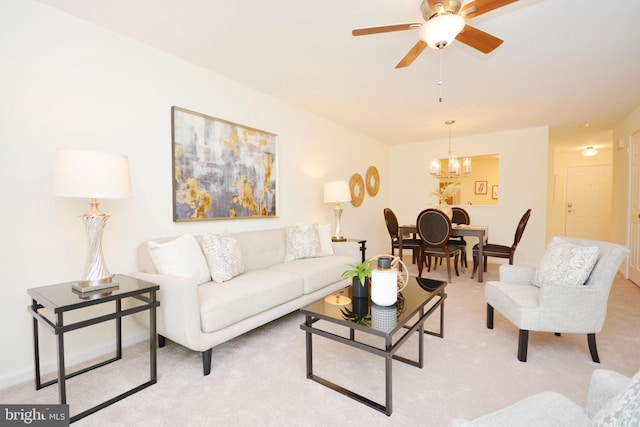 carpeted living room featuring ceiling fan with notable chandelier