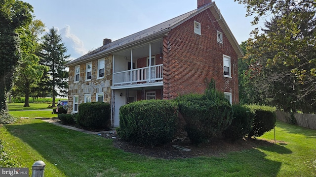 view of home's exterior with a yard and a balcony