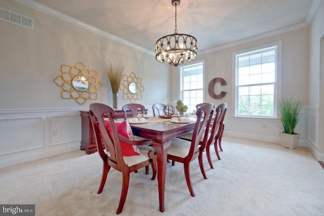 dining area featuring a notable chandelier, light colored carpet, and ornamental molding