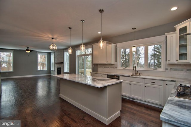 kitchen with white cabinets, pendant lighting, a center island, and ceiling fan