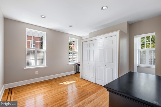 unfurnished bedroom featuring light hardwood / wood-style flooring and a closet