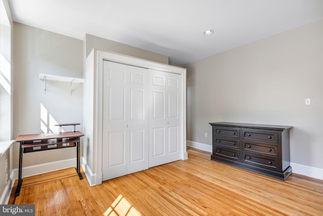 bedroom with light hardwood / wood-style floors and a closet