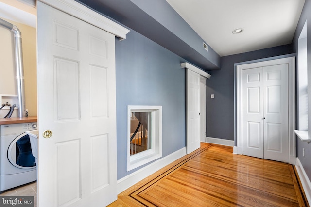 unfurnished bedroom with decorative columns, washer / dryer, light hardwood / wood-style floors, and a closet