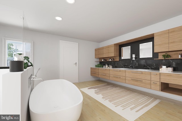 kitchen with light hardwood / wood-style flooring and backsplash