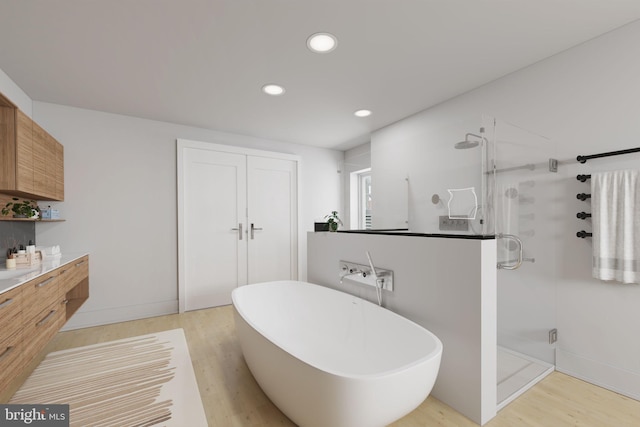 bathroom featuring independent shower and bath, vanity, and wood-type flooring