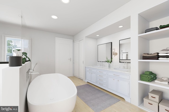 bathroom with vanity, hardwood / wood-style floors, and a washtub