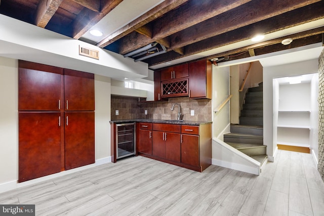 kitchen featuring beamed ceiling, light hardwood / wood-style flooring, backsplash, wine cooler, and sink