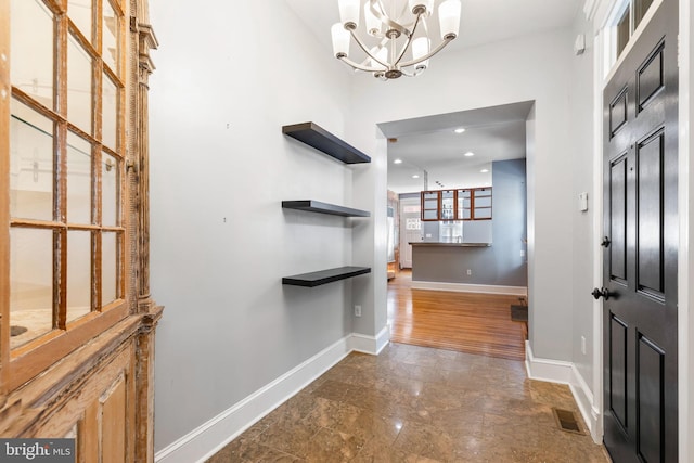 foyer with dark wood-type flooring and a notable chandelier